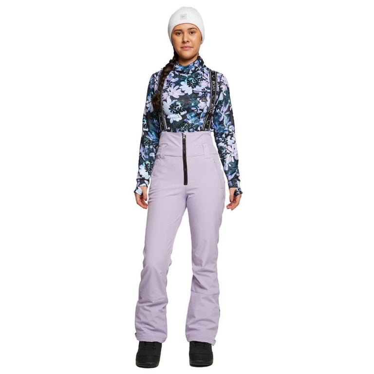 Front view of a woman wearing lavender Rojo softshell high rise ski pants with black suspenders and a front zipper.