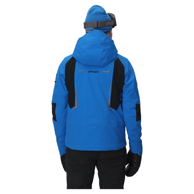 Rear view of a blue Spyder Monterosa ski jacket with black shoulder panels, orange accents, and a hood.