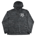 Thrasher THR X SF Thrash & Burn black camo anorak with white chest logo, half-zip, hood, and front pouch pocket.